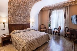 丹吉尔法国别墅格兰德酒店的卧室配有一张床和一张桌子及椅子