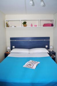 斯廷佳Happy Camp Mobile Homes in Brioni Sunny Camping的一间卧室配有蓝色的床和蓝色床头板