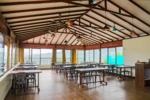 罗纳瓦拉Green Velvet Resort-Near Pawna Lake的用餐室设有桌椅和窗户。