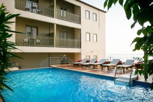 阿吉奥斯伊欧尼斯Kenta Beach Hotel的酒店拥有游泳池和躺椅