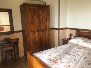 阿杰罗拉拉白塔农庄乡村民宿的一间卧室配有一张床和一个木制橱柜