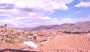 库斯科Hospedaje Pumacurco Betty的一座以红色屋顶和山脉为背景的城市