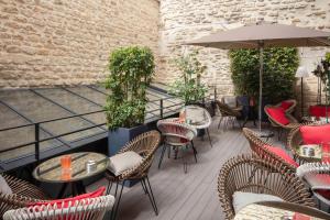巴黎阿斯托利亚塞瓦斯托波尔123酒店的一个带桌椅和遮阳伞的庭院