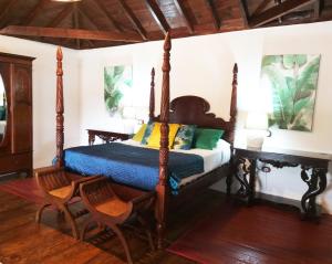 罗萨里奥港Rural Rugama的一间卧室配有四柱床和两把椅子