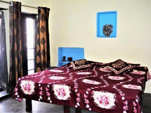 瓦拉纳西Shiva lodge的一间卧室配有一张带紫色棉被的床