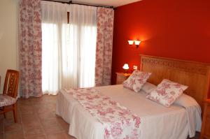 代米耶尔代米厄尔埃尔科提约酒店的一间卧室设有一张红色墙壁和窗户的床