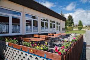 菲希塔赫KNAUS Campingpark Viechtach的一座建筑外带桌椅和鲜花的庭院