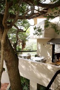 德班Teremok Lodge & Spa的一座带桌子的建筑前的树