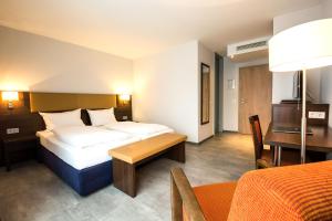 慕尼黑domus Hotel的酒店客房设有两张床和一张桌子。