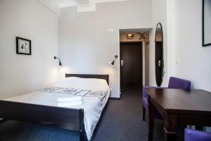 弗罗茨瓦夫瓦特拉旅馆的一间卧室配有一张床、一张桌子和一张桌子