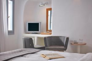 菲罗斯特法尼天涯套房酒店的一间卧室配有一张桌子、一台电脑和一把椅子