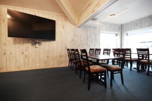 桑内舍恩Napoli Resturant & Hotell AS的一间会议室,配有桌椅和一台平面电视