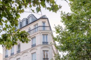 巴黎9Hotel Bastille-Lyon的一座白色的建筑,上面设有一个阳台