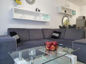 尤斯托尼莫斯基DWIE SOSNY-Apartament Morski Kryształ - 365PAM的客厅配有蓝色的沙发和玻璃桌