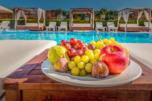 卡沃斯Chandris Apartments的池边桌子上的一盘水果