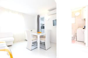 斯科比西奇One bedroom house at Skrpcici 500 m away from the beach with enclosed garden and wifi的白色的客房配有白色的桌子和椅子