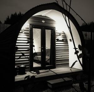 因弗内斯Tomatin Glamping Pods的拱形门,有门进入小房子