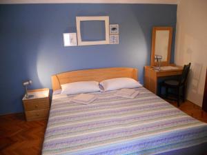 瓦伦Room Dinko的一间卧室配有一张蓝色墙壁的床