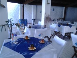佩鲁伊比巴尔加斯佩鲁伊比酒店的一间设有白色桌子和白色椅子的房间,并配上食物