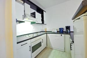 安娜贝格-布赫霍尔茨Ferienwohnung 143的厨房配有白色橱柜和炉灶烤箱。