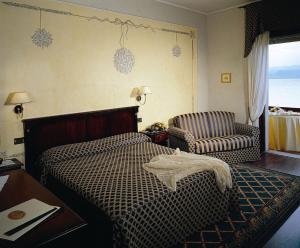 西尔米奥奈路加那帕可阿拉戈酒店的一间卧室配有一张床、一把椅子和一张桌子