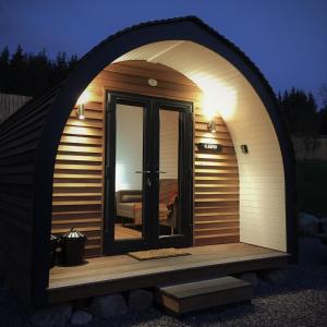 因弗内斯Tomatin Glamping Pods的通往带窗户的桑拿浴室的大型拱形门道