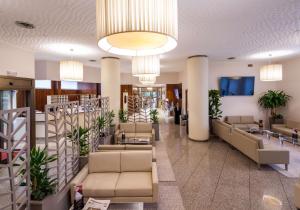 塞格拉泰Best Western Air Hotel Linate的医院的大厅,里面长着长沙发和植物