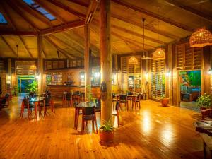TufiTufi Resort的餐厅铺有木地板,配有桌椅