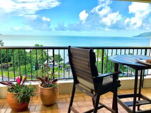 凯恩斯Cairns Apartment Esplanade Ocean Views的阳台设有长凳和桌子,享有海景。
