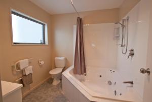 Temuka凤凰汽车旅馆的带浴缸、卫生间和盥洗盆的浴室