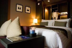 芭堤雅市中心AYA Boutique Hotel Pattaya - SHA Plus的一间酒店客房,配有一张床铺和一张桌子上的蜡烛