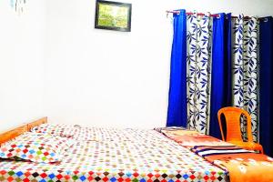 Rāmnagarvinyaka p.g.house的一间卧室配有蓝色窗帘的床