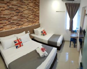 关丹casa 96 villa的一间卧室设有两张床和砖墙