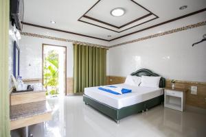 红统府布阿朗精品度假村的一间卧室配有床和绿帘