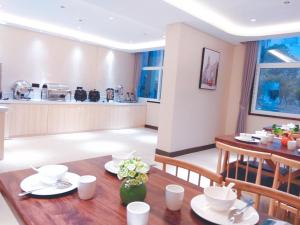 鄂州尚客优精选湖北鄂州鄂城区武汉东海洋世界店的厨房以及带木桌和椅子的用餐室。