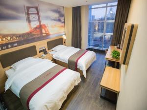 邯郸尚客优精选河北邯郸丛台区联纺西路店的酒店客房设有两张床和大窗户。