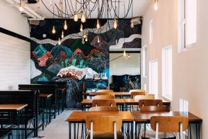 满洲乡日日旅海的餐厅设有木桌和墙上的大壁画