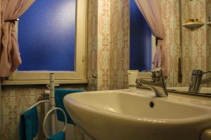 罗马罗马四季住宿加早餐酒店的一间带水槽和蓝色窗户的浴室
