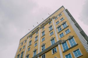 吉隆坡Hotel Venice的黄色的建筑,上面有白色的窗户