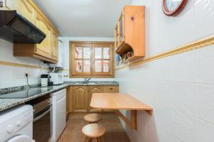 卡尼略Apartamento Refugi的一间带木制橱柜和木桌的小厨房