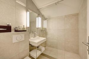 慕尼黑阿德米瑞酒店的白色的浴室设有水槽和镜子