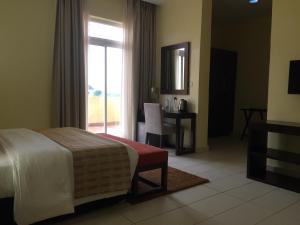 Ado EkitiAMOR Hotel Ekiti的一间卧室配有一张床、一张书桌和一个窗户。