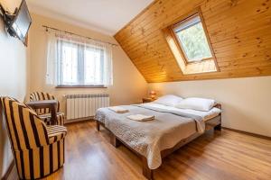 下乌斯奇基Noclegi u Kiesza的一间卧室设有一张床、一个窗口和一把椅子