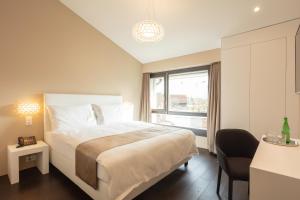 拉珀斯维尔-约纳Hotel Lo! im Kreuz Jona的卧室设有一张白色大床和一扇窗户。
