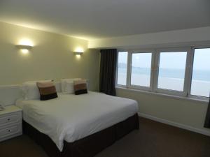 圣布雷拉德博尔里维格公寓酒店的一间卧室配有一张带白色床单和窗户的床。