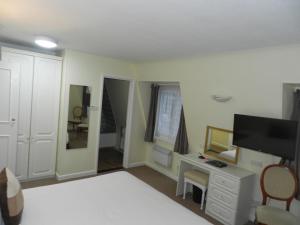 圣布雷拉德博尔里维格公寓酒店的一间卧室配有一张床、一张书桌和一台电视