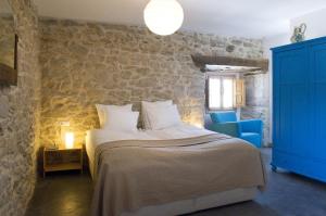 HedesoHotel Rural Casa La Sonrisa的一间卧室设有一张大床和石墙