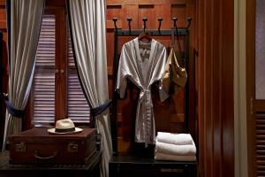 琅勃拉邦琅勃拉邦布拉莎丽传统酒店的一间配备西装、帽子和手提箱的房间