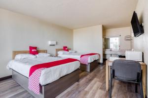 韦科OYO Hotel Waco University Area I-35的一间设有两张床铺和红色枕头的客房