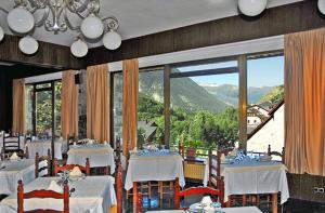 萨拉尔杜迦罗娜酒店的一间设有白色桌子和大窗户的用餐室